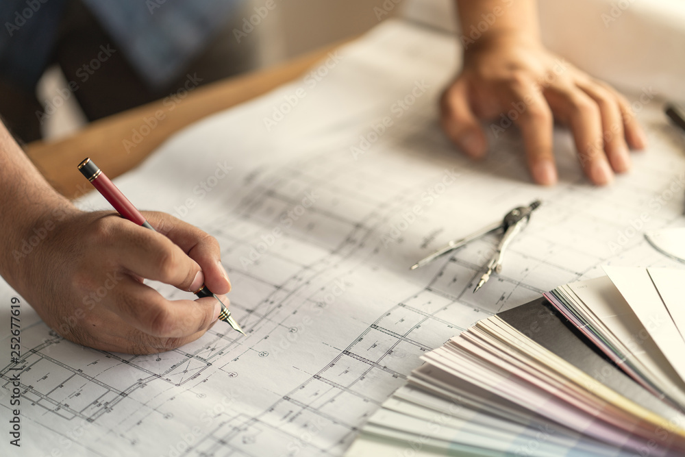 Architect & Engineer working drawing document about project planning and progress of work schedule on the home building construction site Architect & Engineer working drawing document about project planning and progress of work schedule on the home building construction site