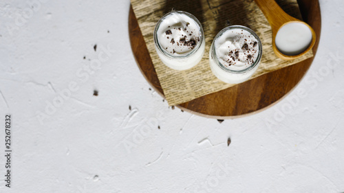 Homemade natural greek yogurt in glass jars with chocolate.Top view.