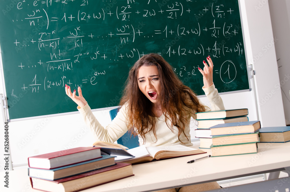 Young female math teacher in front of chalkboard Young female math teacher in front of chalkboard