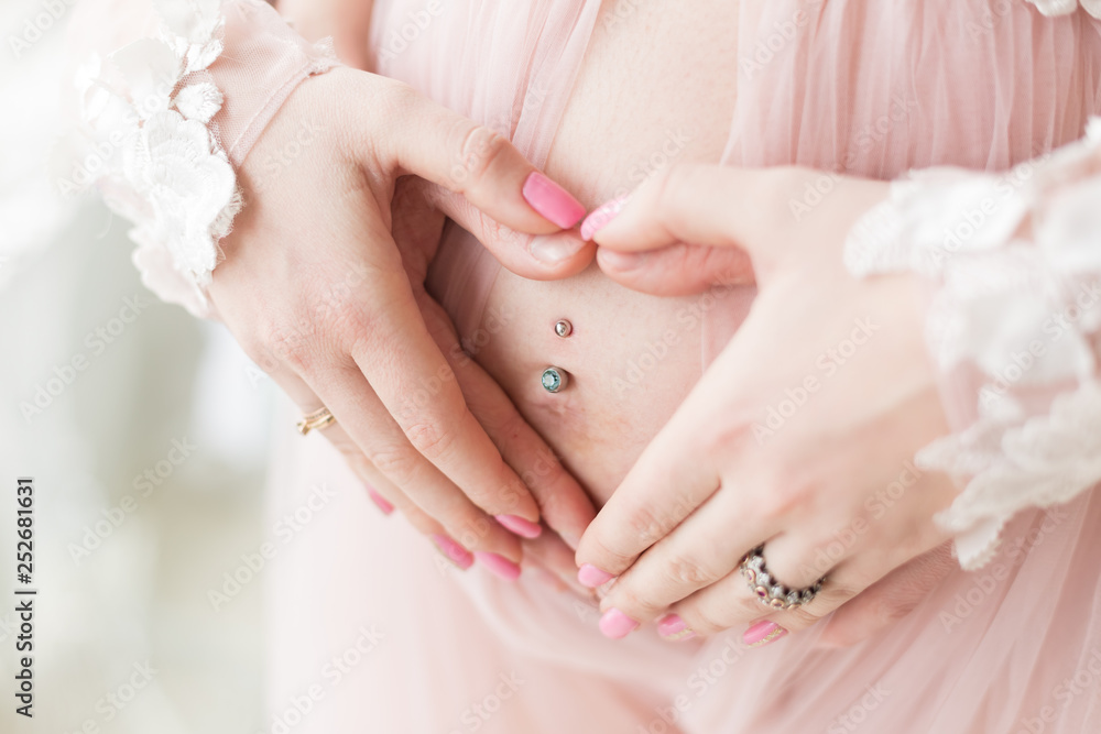 hands men and women on pregnant belly. hands folded fingers little heart on his stomach. pregnant belly hands men and women on pregnant belly. hands folded fingers little heart on his stomach. pregnant belly