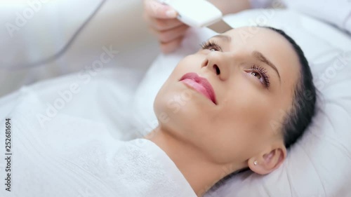 Close-up etalon female young face with perfect skin during ultrasonic peeling at beauty salon photo