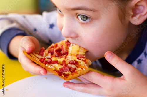 The child eats pizza.