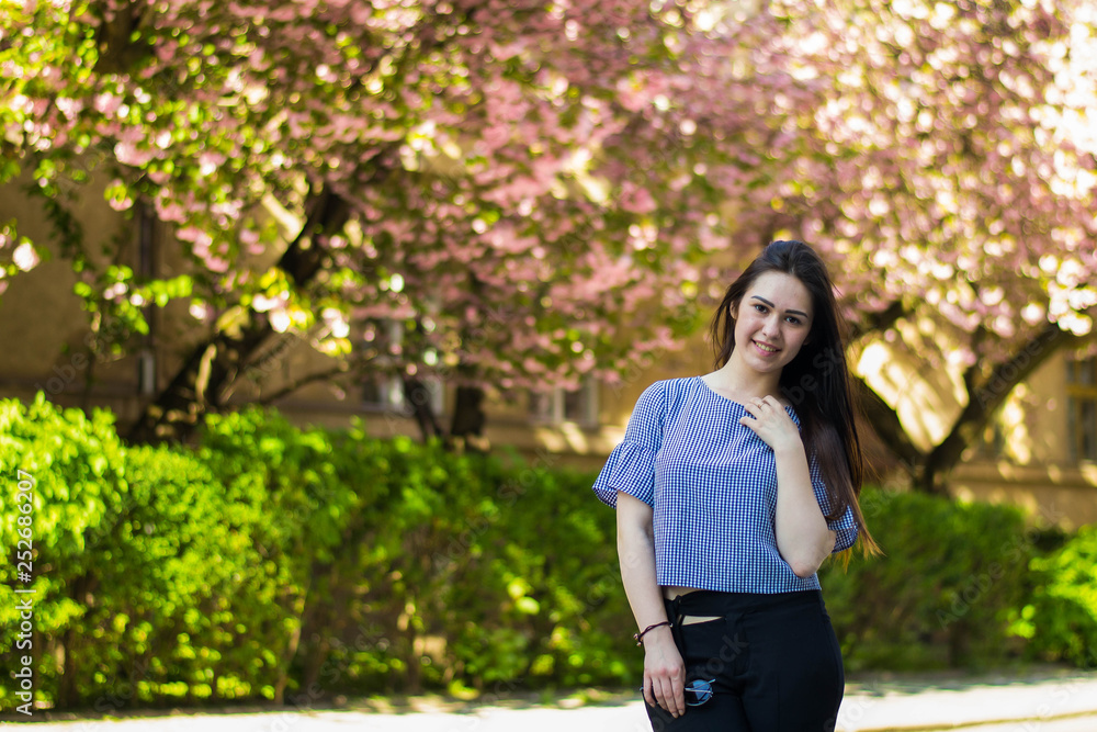 Plus size fashion model in casual clothes, overweight female body in a park outdoors. Spring concept. Plus size fashion model in casual clothes, overweight female body in a park outdoors. Spring concept.
