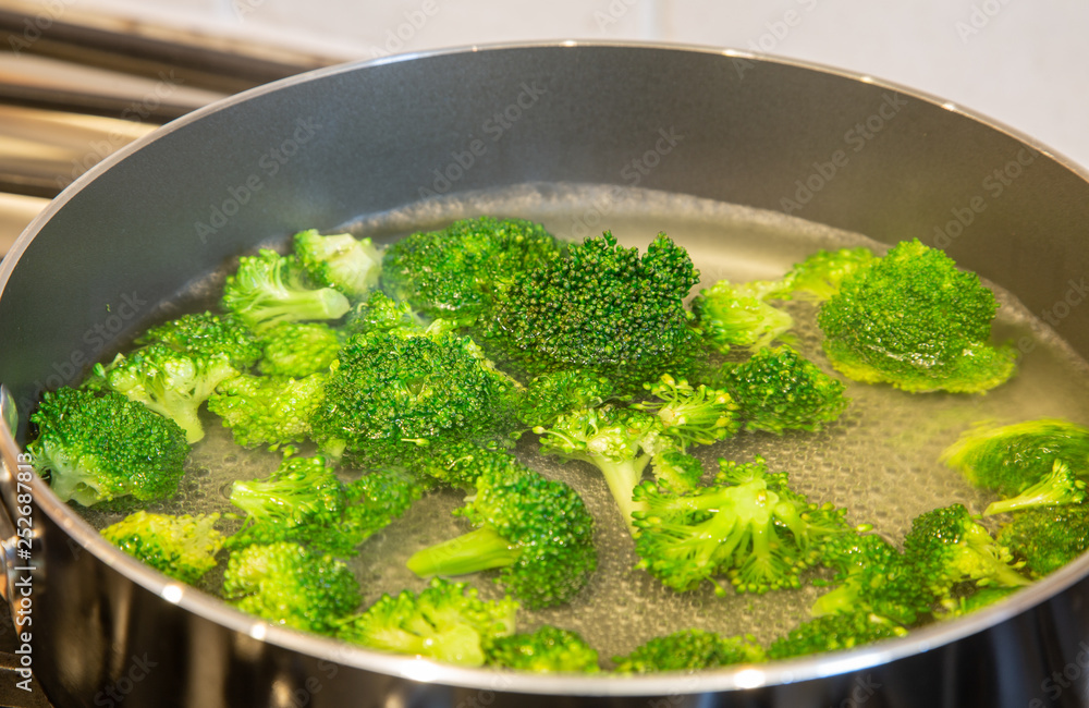 Blanching the broccoli to a bright green in boiling water Blanching the broccoli to a bright green in boiling water