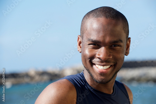 Close up happy young african american smiling by the sea