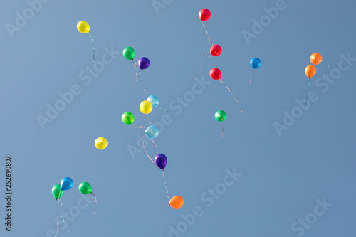 Lots of colorful balloons flying to the blue sky