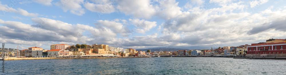 The city of Chania is a port on the west coast of the Cretan Sea in Greece. A tourist attraction, a long quay, interesting architecture, a Turkish bath building, houses. Mountains on the horizon.