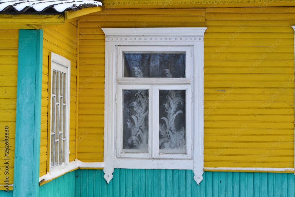 Vintage window frame in traditional russian village close up. Wooden background. Front view.