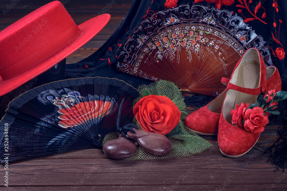 Beautiful and bright accessories for flamenco dance on a wooden background  in a low key. Shawl, hat, fan, shoes, castanets and a flower for the hair.  Stock Photo | Adobe Stock