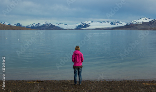 A girl stands on the shores of the Greenland Sea