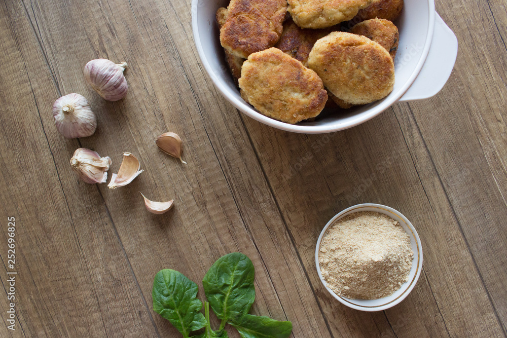 Fried cutlet on wooden table with garlic Fried cutlet on wooden table with garlic