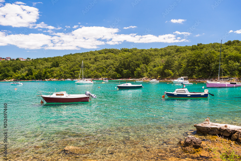 Boats in a turquoise water in a bay near Malinska, Croatia. Summer holidays, travel concept. Boats in Mediterranean Sea. Tourists boats in Adriatic sea.