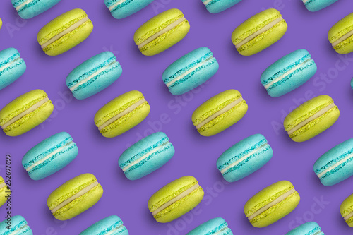 Macaroons on colored background, a pattern of colorful french cookies macarons. Beige, brown french cookies macarons on mint blue cyan background. Gift for Valentine's Day and 8 March
