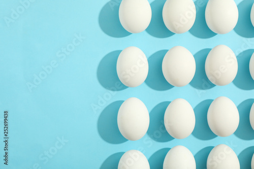 Flat lay composition with chicken eggs on color background, space for text