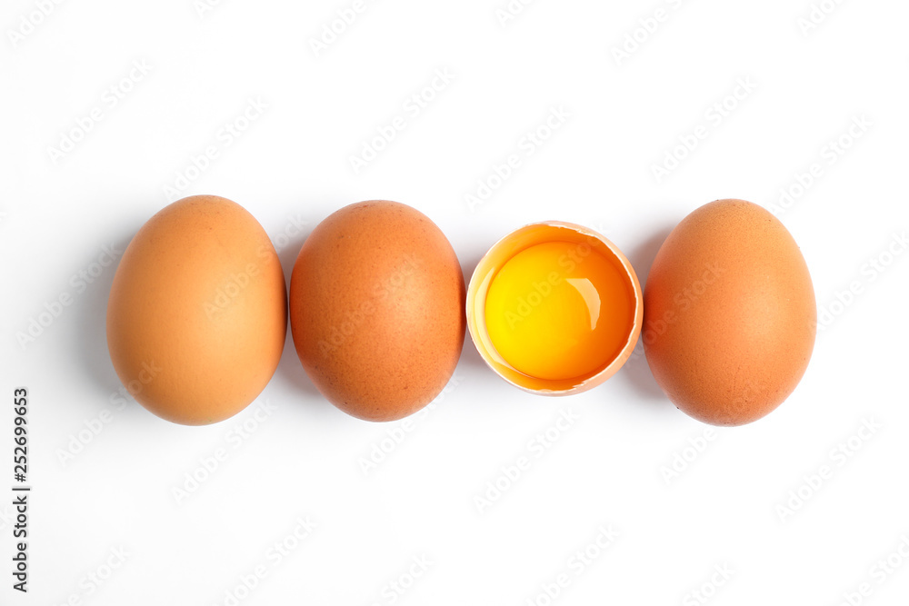 Chicken eggs and half yolk on white background, space for text Chicken eggs and half yolk on white background, space for text