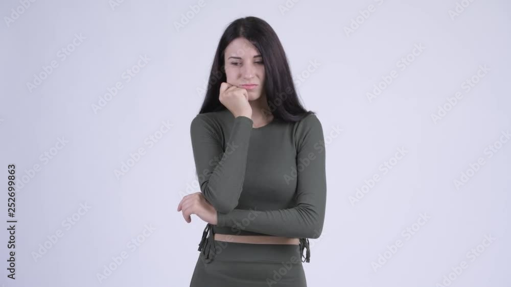 Serious young woman thinking and looking down Serious young woman thinking and looking down