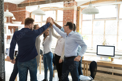 Businesspeople standing giving high five celebrating great results photo