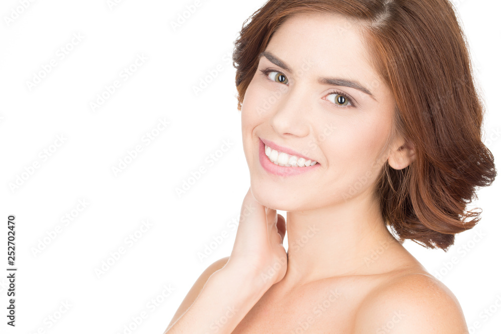 Healthy and beautiful. Close up studio portrait of a young female touching her neck and smiling to the camera Healthy and beautiful. Close up studio portrait of a young female touching her neck and smiling to the camera