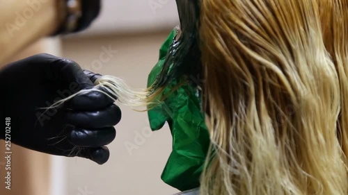 Professional hairdresser dyeing hair. Multicolor with stretching coloring. Fluorescent staining