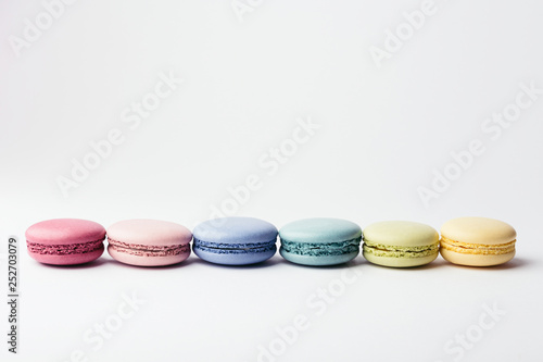 Row of colorful macarons on white background. Top view.