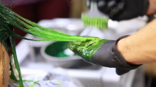 Professional hairdresser dyeing hair. Multicolor with stretching coloring. Fluorescent staining