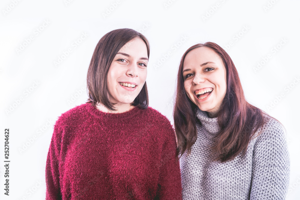 two friends or lesbians on a white background, smiling and laughing in the company of each other. The concept of female friendship and love two friends or lesbians on a white background, smiling and laughing in the company of each other. The concept of female friendship and love