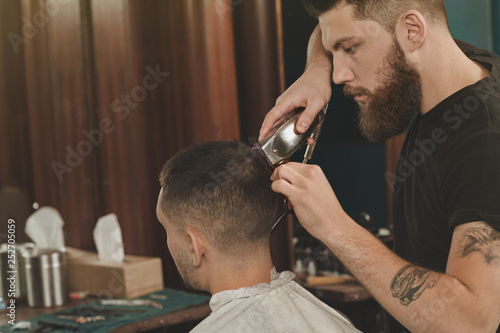 A bit more here. Bearded barber finishing his work on hairstyling