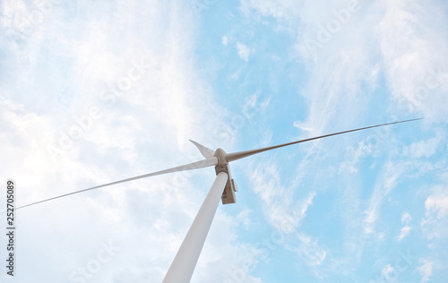 Row of wind power generators on blue sky background