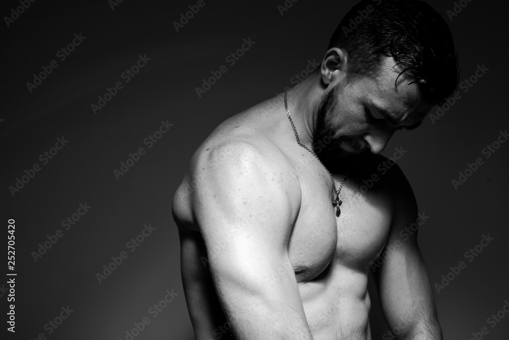 Naklejka premium Black and white photo of a handsome and sporty guy close-up in studio