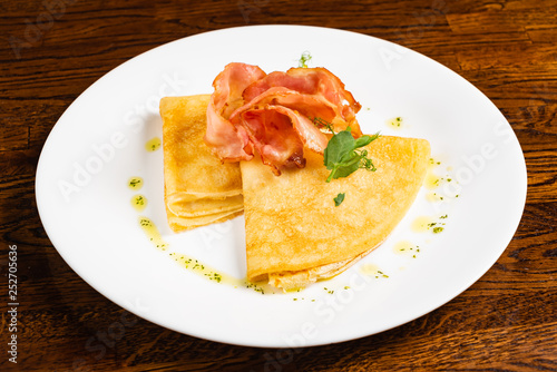 crepes with bacon ont he wooden background