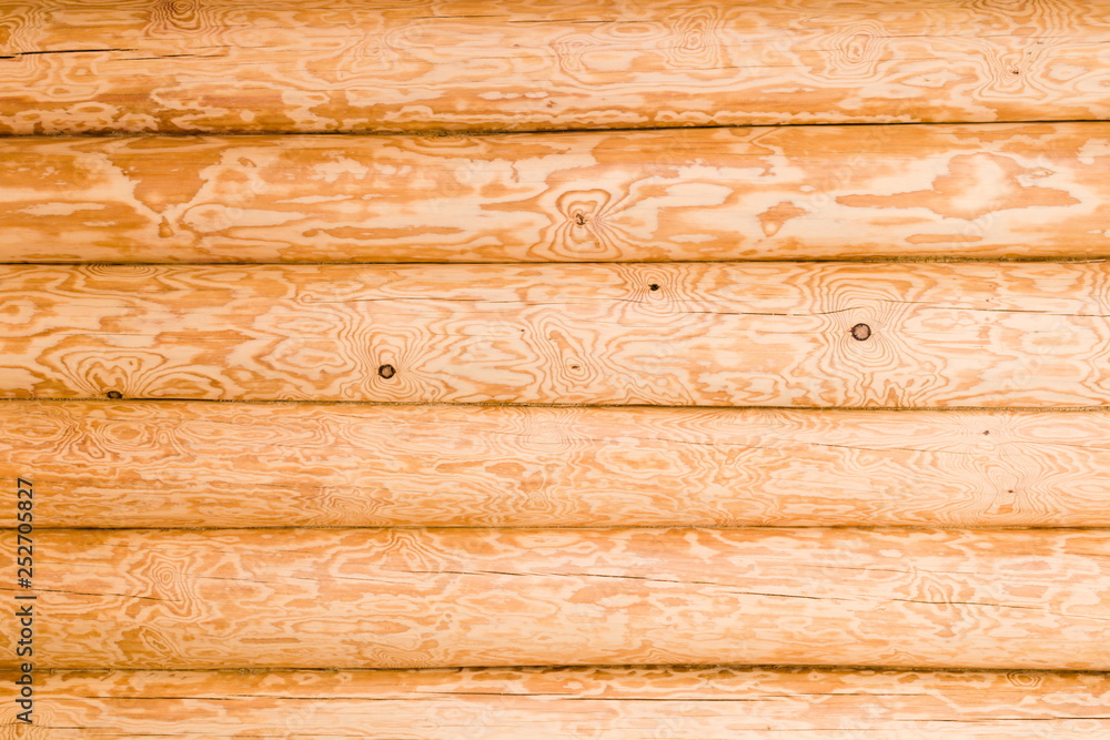 Naklejka premium Wall of wooden houses built of round logs