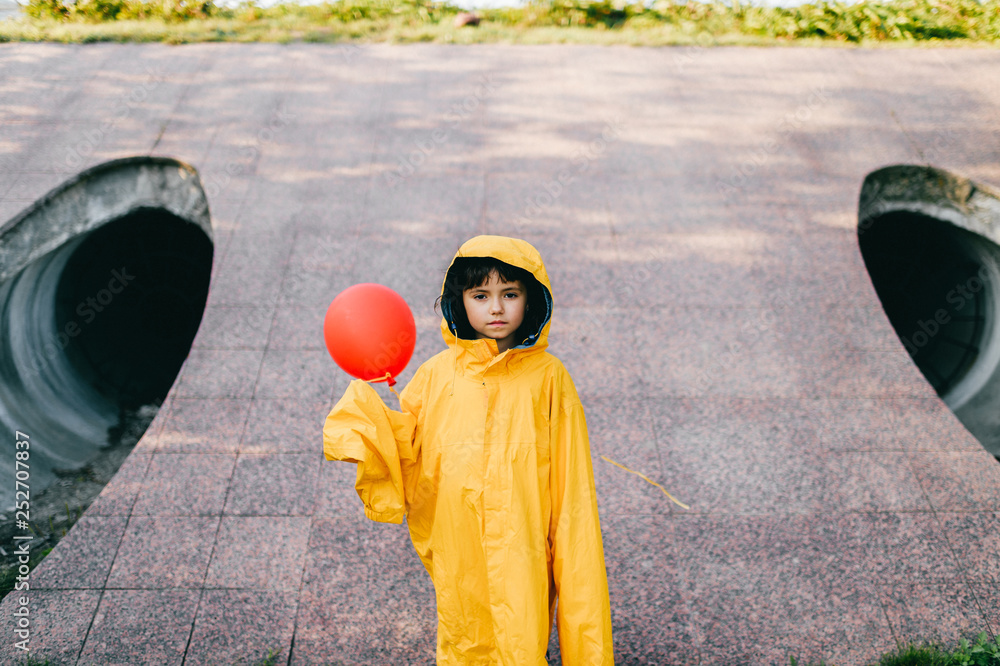 Bedrag nyt år Marquee Portrait of pretty litle girl in big adult oversized yellow raincoat with red  balloon in hand