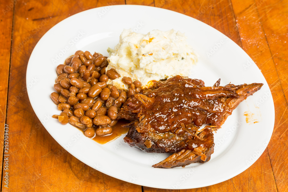 Barbecue Beef Brisket on Platter with Beans and Potato Salad in Rustic Setting Barbecue Beef Brisket on Platter with Beans and Potato Salad in Rustic Setting