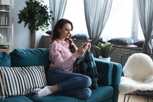 Young beautiful woman using smartphone at home.