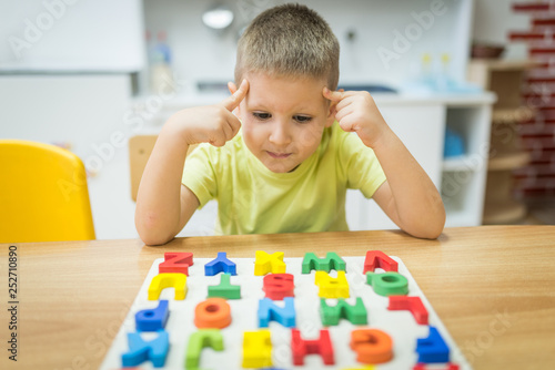 Thinking little boy solve puzzle