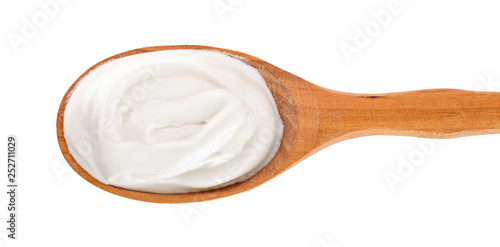 Sour cream in wooden spoon isolated on white background. Top view. Flat lay