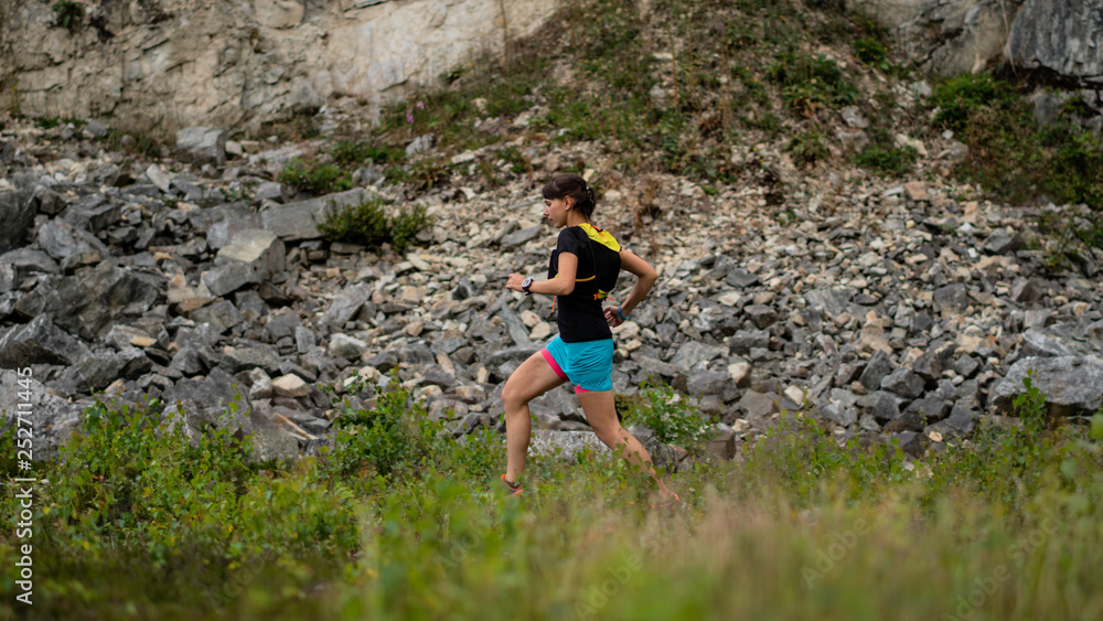 Fototapeta premium Girl athlete runs a long trail running on a beautiful area along the cliff. Healthy lifestyle