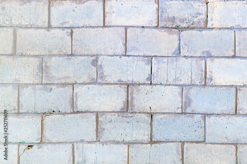 Background with brickwork texture. Light gray wall lined with large bricks.