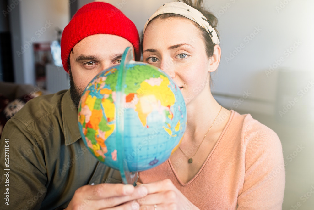 Portrait of Happy young couple with globe choosing place for summer journey. Family travel concept Portrait of Happy young couple with globe choosing place for summer journey. Family travel concept