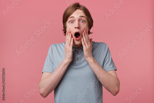 Εκτύπωση καμβά Close up of young man with blown away, amazed expression and dropped jaw isolated on pink background
