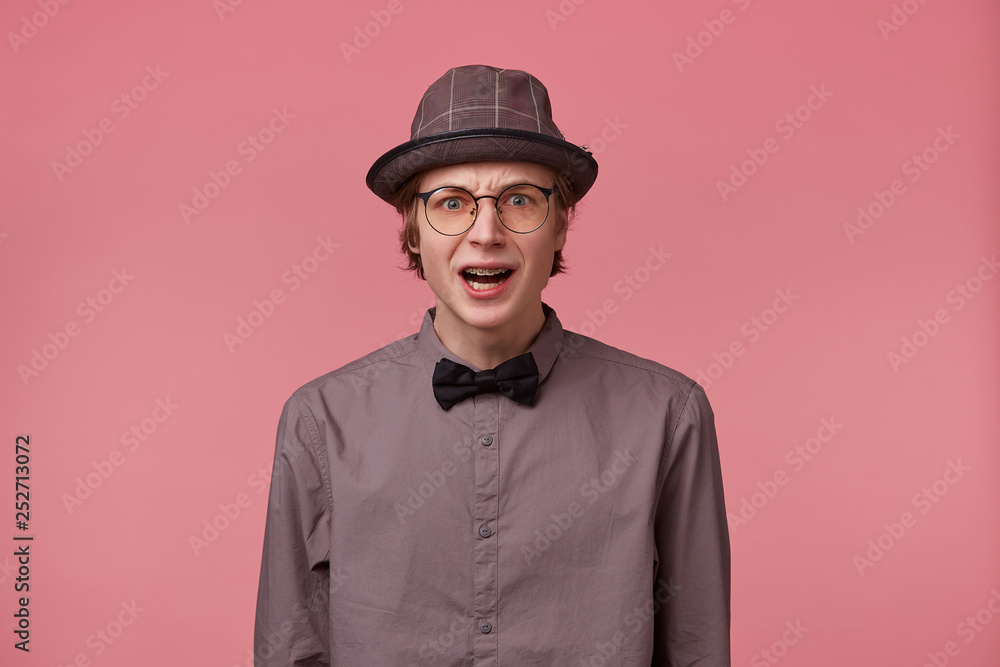 Stupefied guy looks with astonishment into camera, being amazed with incredible unbelievable positive news. Emotional hipster guy expresses surprisment, doesn`t believe his eyes. Facial expression