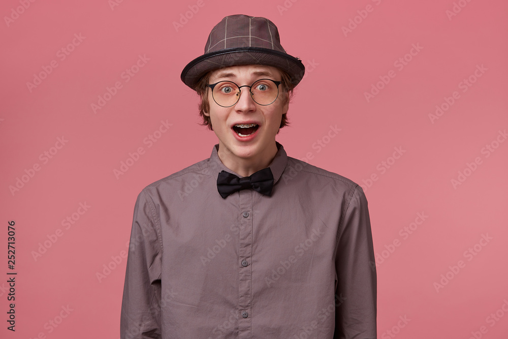 Stupefied guy looks with astonishment into camera, being amazed with incredible unbelievable positive news. Emotional hipster guy expresses surprisment, doesn`t believe his eyes. Facial expression Stupefied guy looks with astonishment into camera, being amazed with incredible unbelievable positive news. Emotional hipster guy expresses surprisment, doesn`t believe his eyes. Facial expression