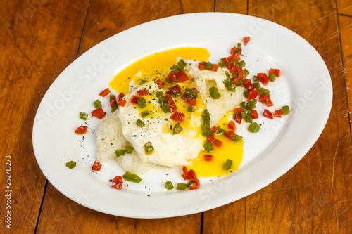 Eggs Over Easy on Grits with Colorful Spices for Brunch on Rustic Surface