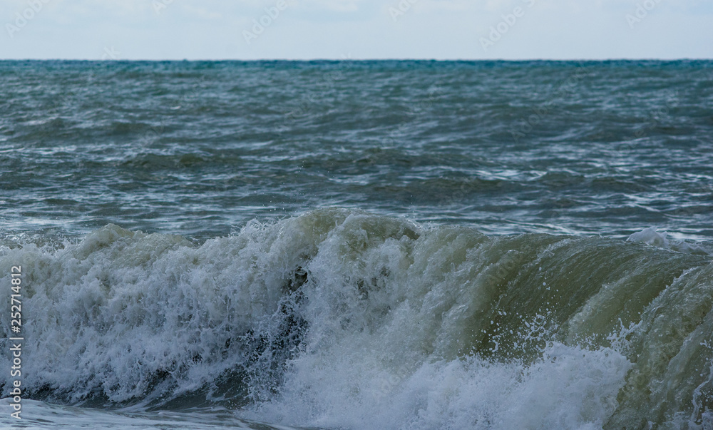 Fototapeta premium sea landscape is a pebbly beach with waves in white foam