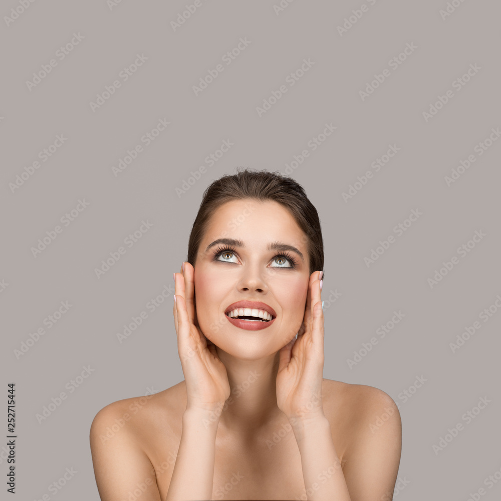 Portrait of young woman. Perfect clean skin and beautiful smile. Gray background. Portrait of young woman. Perfect clean skin and beautiful smile. Gray background.