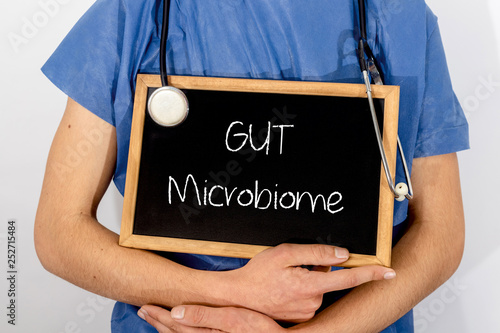Doctor shows information on blackboard: GUT Microbiome.  Medical concept.