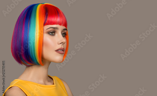 Portrait of beautiful woman. Colorful hair. Gray background.