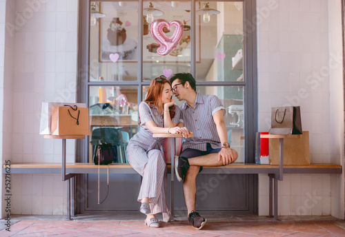Asian couple sitting and talking happily after shopping.