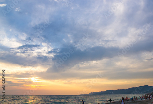 Amazing sea sunset on the pebble beach, the sun, waves, clouds