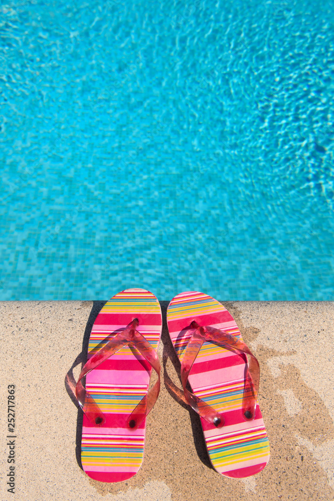Fototapeta premium Flip flops at the swimming pool